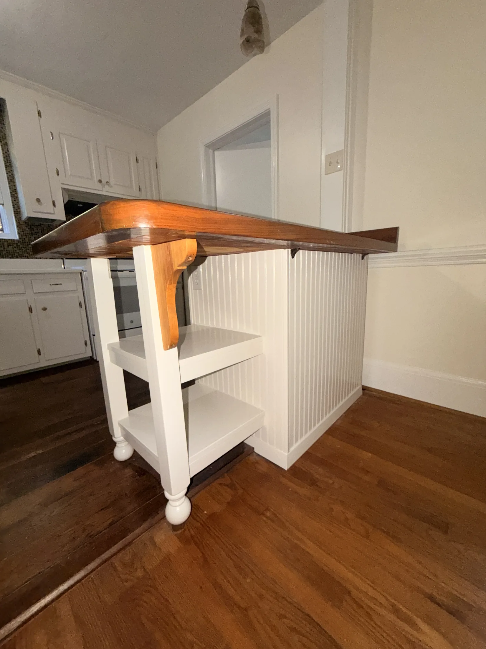 White built-in kitchen island with a stained wood top