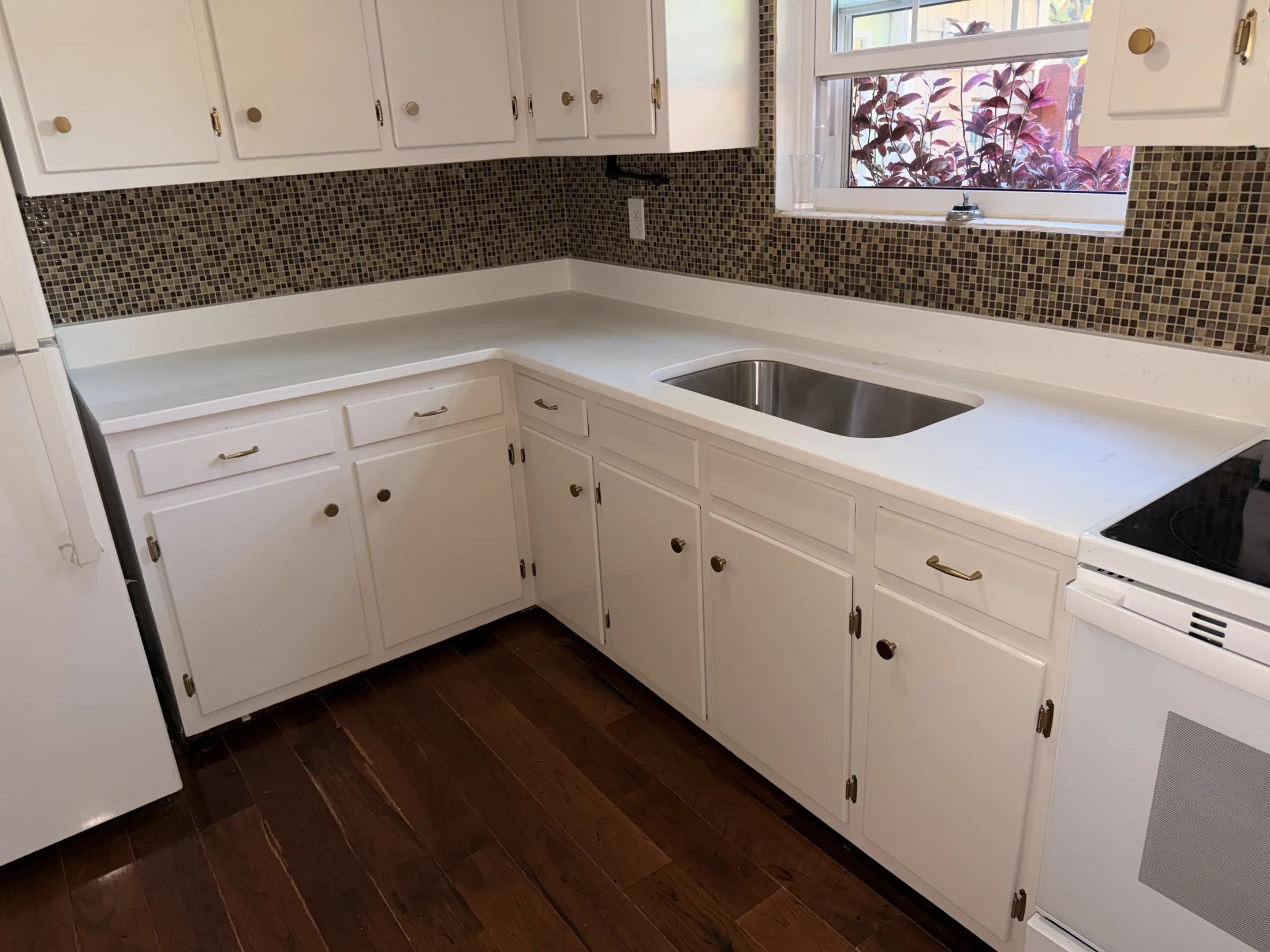 Completed white kitchen cabinets, countertop, and sink area