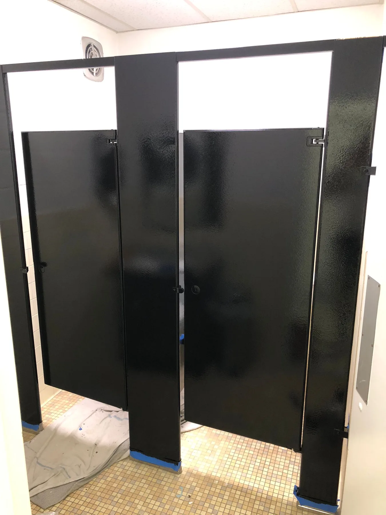 Commercial restroom partitions completed in a glossy black finish