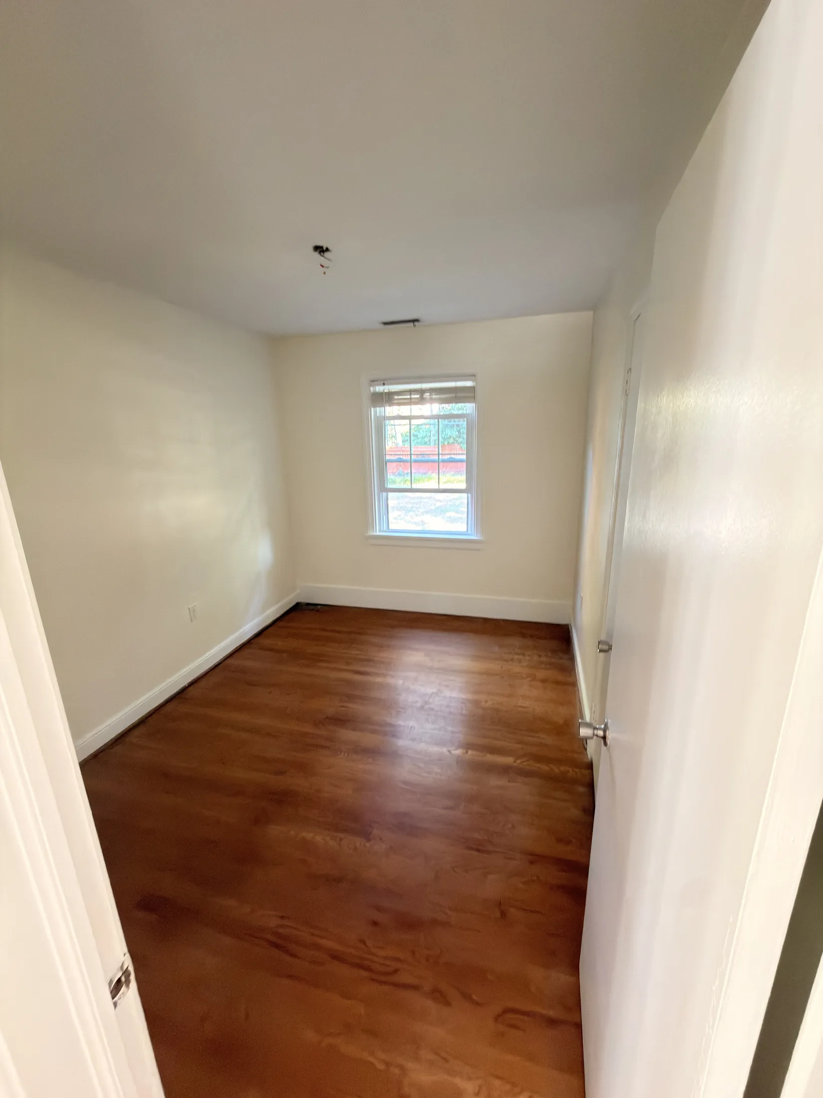 Completed bedroom with warm neutral walls and white trim