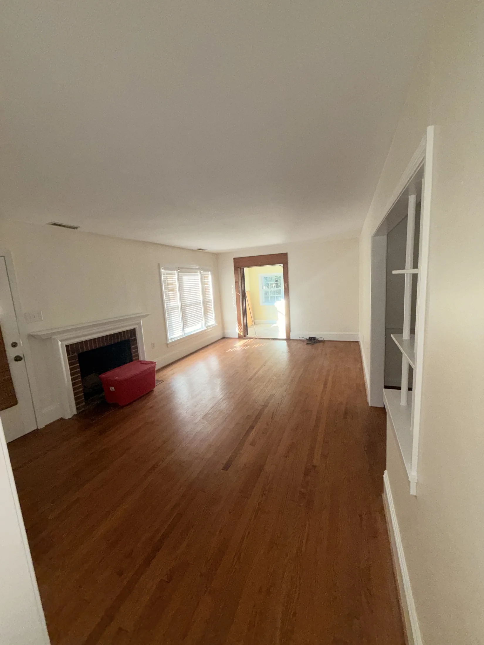 Completed living room with neutral walls, white trim, and hardwood floors
