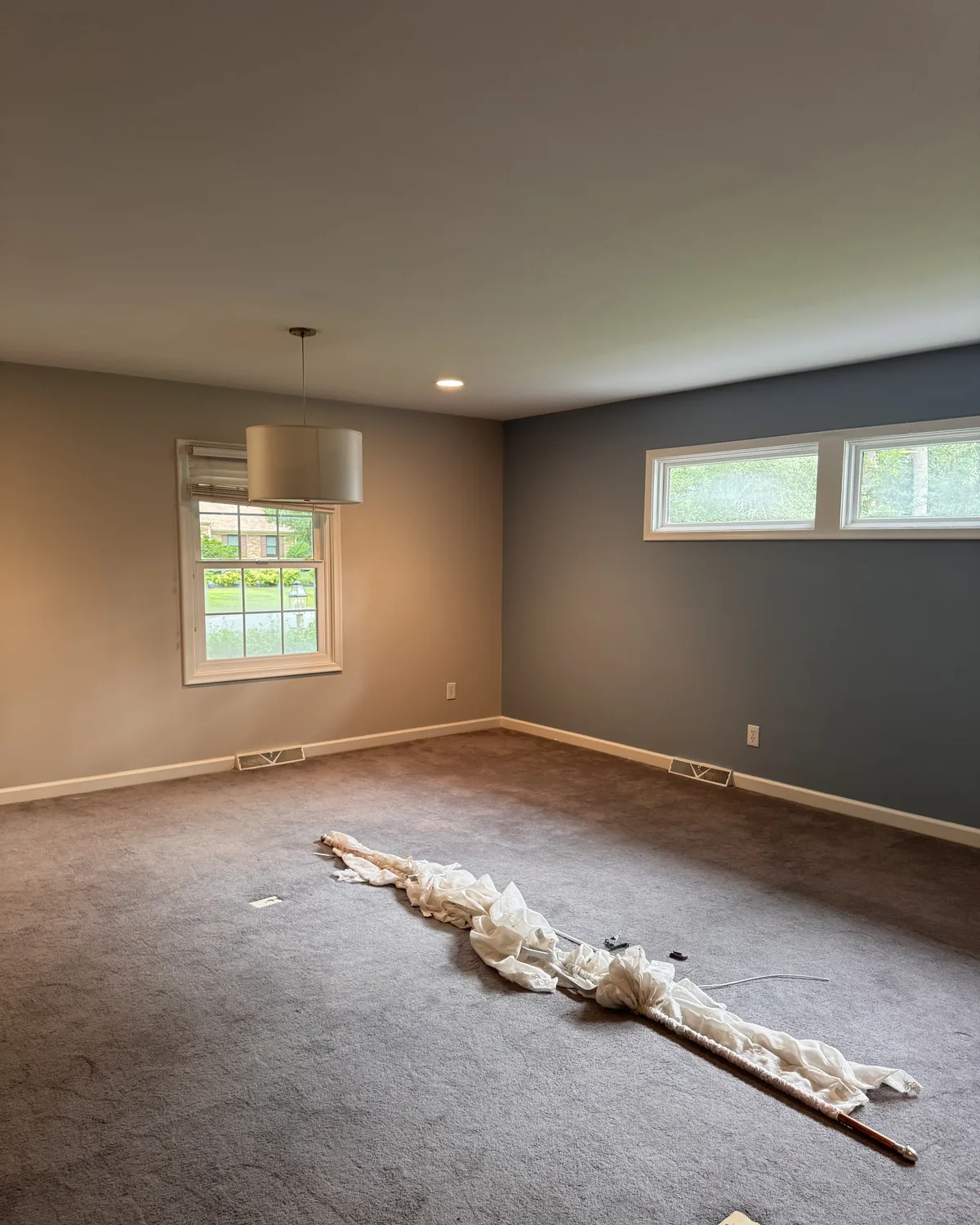 Large room repainted with neutral walls and a blue-gray accent wall