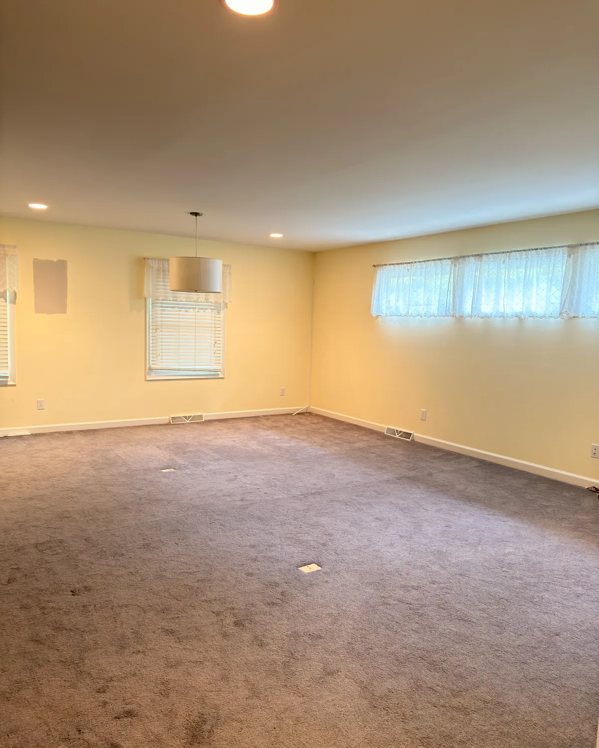Large room with warm yellow walls before painting