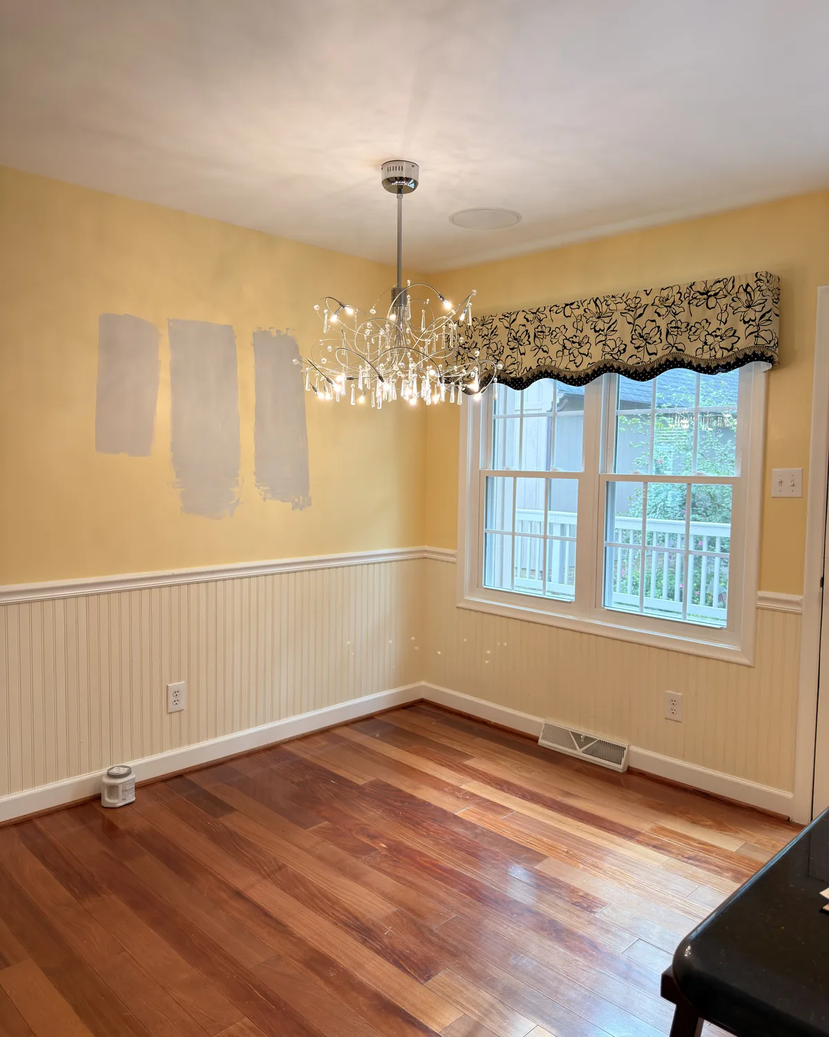 Dining room with yellow walls and paint color samples before the refresh